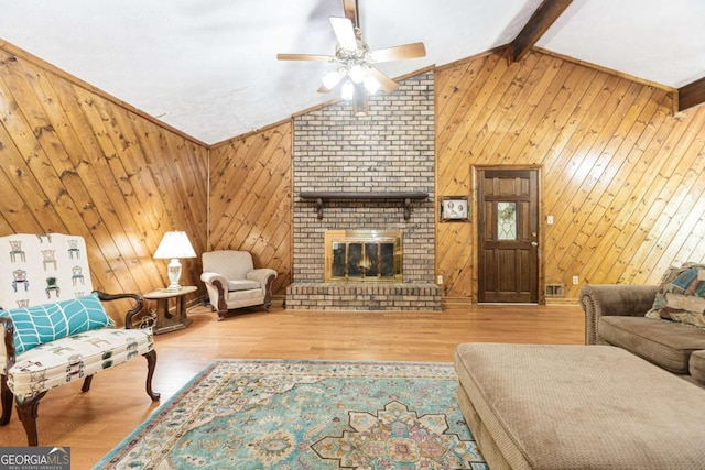2228 Walker Dr, Lawrenceville, GA 30043 - living room featuring ceiling fan, wood finished floors, a fireplace, and wooden walls
