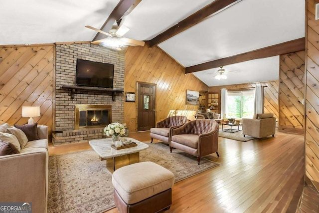 2228 Walker Dr, Lawrenceville, GA 30043 - living room featuring a ceiling fan, wooden walls, hardwood / wood-style flooring, and a fireplace