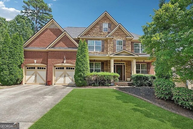 view of front of property featuring driveway, a front lawn, stone siding, and brick siding