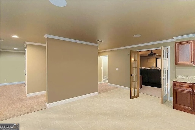 spare room featuring crown molding, recessed lighting, baseboards, and light carpet