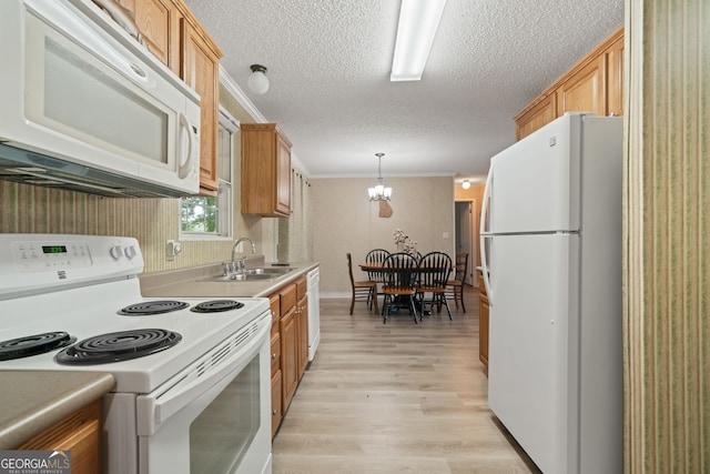 194 Phillips Dr, Eatonton, GA 31024 - kitchen featuring white appliances, a sink, light wood finished floors, a textured ceiling, and pendant lighting
