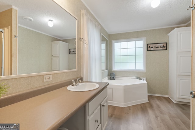 194 Phillips Dr, Eatonton, GA 31024 - bathroom with crown molding, a textured ceiling, wood finished floors, a garden tub, and vanity