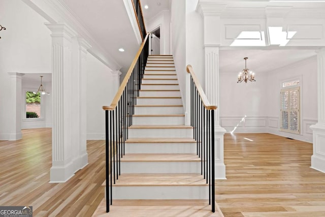 8745 Islesworth Ct, Duluth, GA 30097 - staircase with plenty of natural light, wood finished floors, decorative columns, ornamental molding, and a decorative wall
