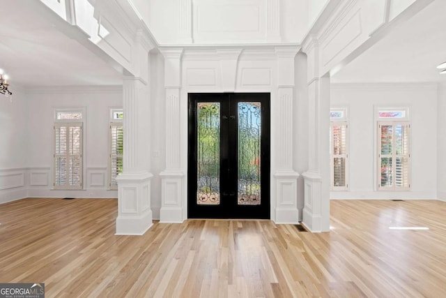 8745 Islesworth Ct, Duluth, GA 30097 - foyer entrance with french doors, a decorative wall, light wood-style flooring, ornamental molding, and decorative columns