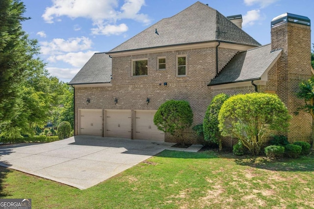 8745 Islesworth Ct, Duluth, GA 30097 - view of home's exterior featuring brick siding, driveway, a lawn, and a chimney