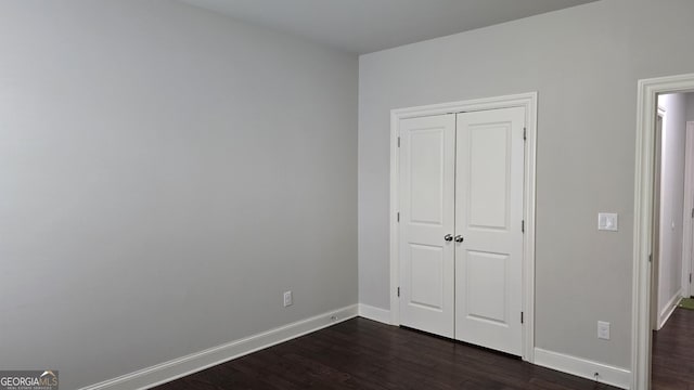605 Lanshire Dr, Alpharetta, GA 30004 - unfurnished bedroom featuring dark wood-style floors, baseboards, and a closet