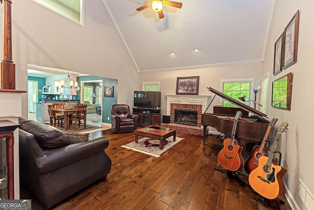living room with high vaulted ceiling, a chandelier, ceiling fan, hardwood / wood-style flooring, and a fireplace