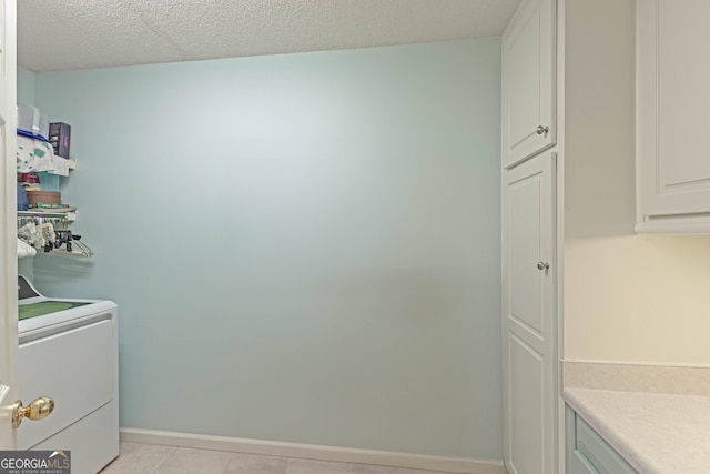 washroom with cabinet space, baseboards, washer / dryer, and light tile patterned floors
