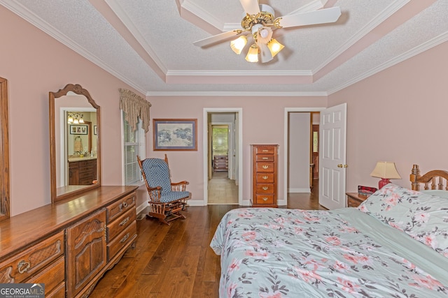 bedroom with a raised ceiling, crown molding, dark wood-style floors, baseboards, and ceiling fan