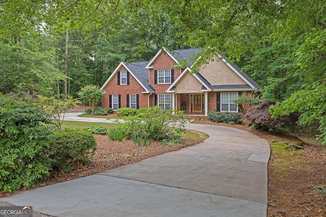 traditional-style house featuring brick siding and driveway