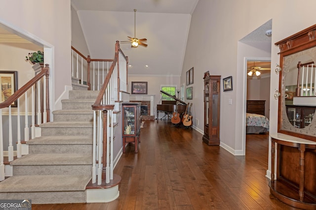 entryway with ceiling fan, high vaulted ceiling, stairway, and dark wood-style flooring