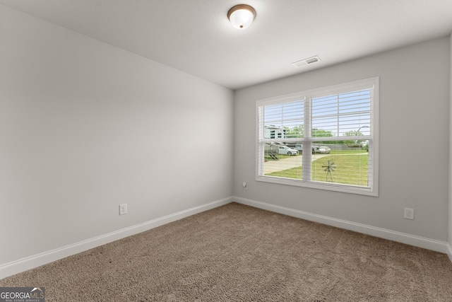 carpeted spare room featuring baseboards