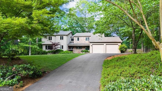 view of front facade featuring an attached garage, asphalt driveway, and stucco siding