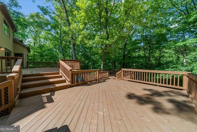 wooden terrace featuring view of scattered trees