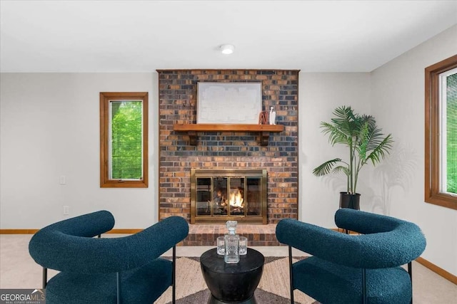 living area featuring baseboards, a fireplace, and carpet
