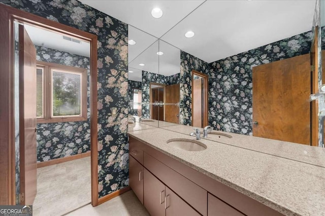 bathroom with wallpapered walls, baseboards, recessed lighting, and vanity