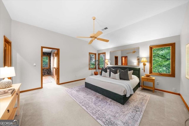 bedroom with multiple windows, light colored carpet, lofted ceiling, and baseboards