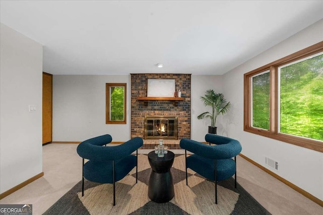 living area with light colored carpet, baseboards, and a brick fireplace