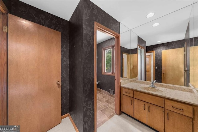 bathroom with vanity, recessed lighting, and baseboards