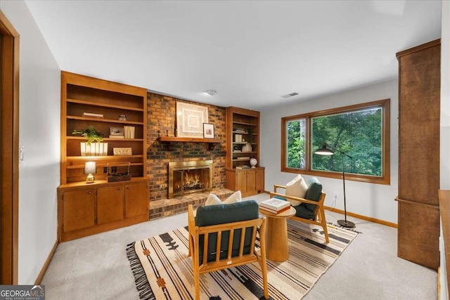 home office featuring baseboards, light colored carpet, a fireplace, and built in features