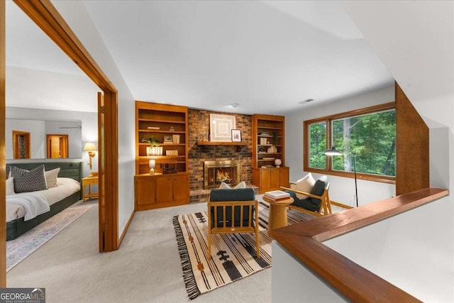 living area with built in features, light colored carpet, a brick fireplace, and baseboards