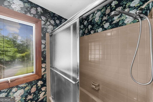 full bathroom with wallpapered walls and a shower with shower door