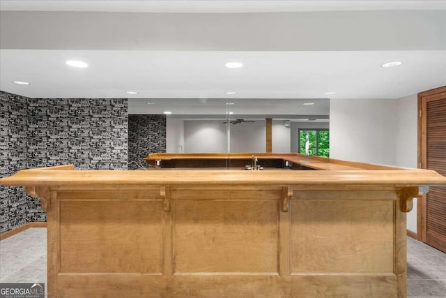 indoor bar with recessed lighting, light tile patterned floors, and baseboards