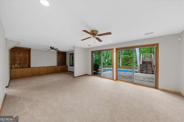 unfurnished living room with a ceiling fan and carpet flooring