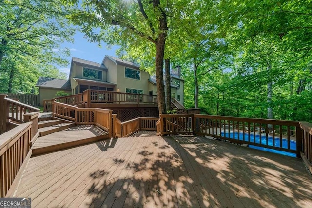 wooden deck with an outdoor pool and stairs