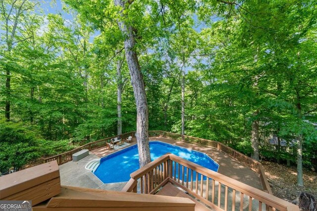 outdoor pool with a wooden deck