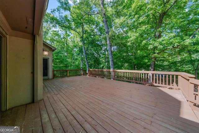 wooden terrace with view of wooded area