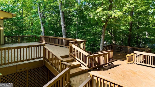 wooden terrace featuring stairway and view of scattered trees