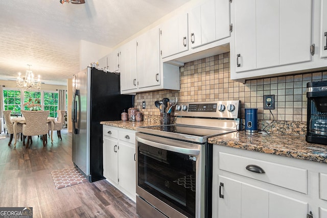 375 Buckwood Trl, Cornelia, GA 30531 - kitchen featuring appliances with stainless steel finishes, a chandelier, wood finished floors, decorative backsplash, and a textured ceiling