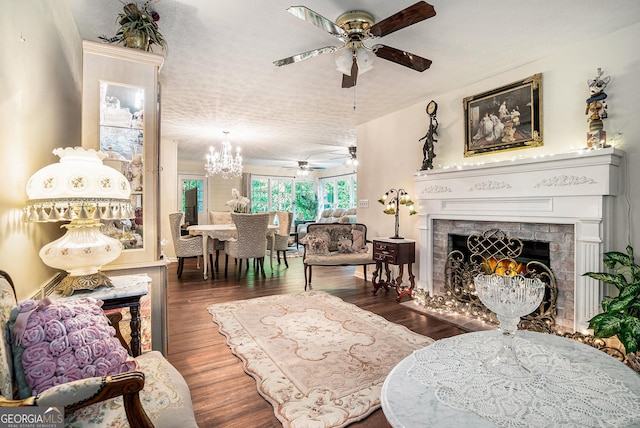 375 Buckwood Trl, Cornelia, GA 30531 - living room featuring a ceiling fan, a fireplace with flush hearth, wood finished floors, a chandelier, and a textured ceiling