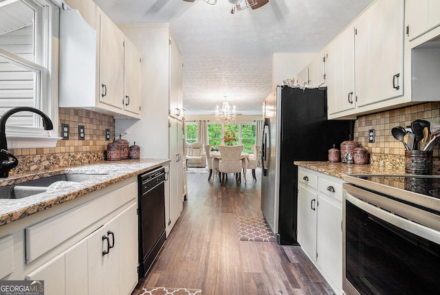 375 Buckwood Trl, Cornelia, GA 30531 - kitchen with black dishwasher, electric range, dark wood-type flooring, a sink, and a chandelier