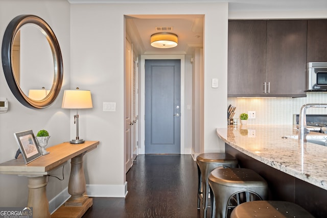 3630 Peachtree Rd NE Unit 1909, Atlanta, GA 30326 - kitchen featuring stainless steel microwave, baseboards, dark brown cabinets, dark wood-style floors, and tasteful backsplash