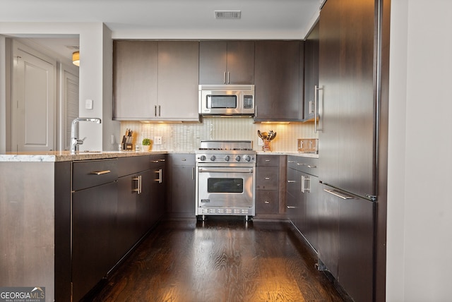 3630 Peachtree Rd NE Unit 1909, Atlanta, GA 30326 - kitchen featuring high quality appliances, dark wood-type flooring, light stone countertops, tasteful backsplash, and a peninsula
