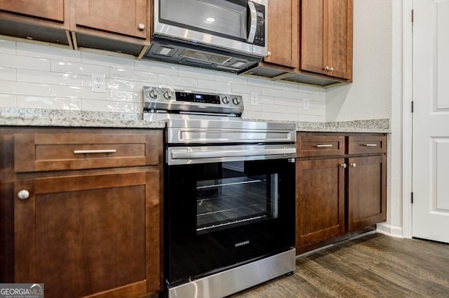 180 Oliver Dr, Locust Grove, GA 30248 - kitchen featuring stainless steel appliances, dark wood-style floors, backsplash, and light stone counters