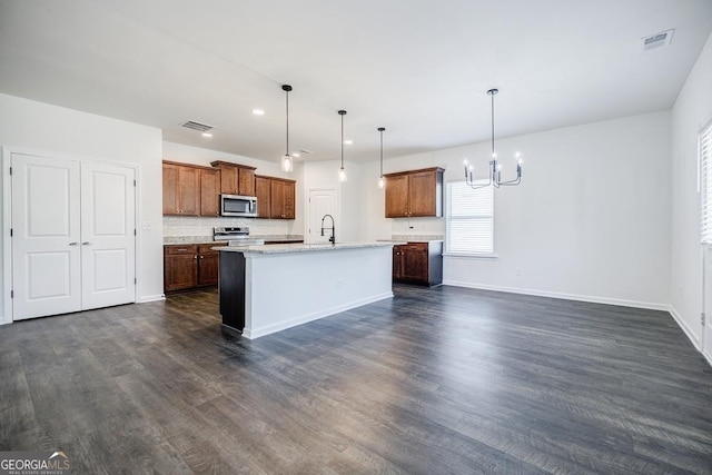180 Oliver Dr, Locust Grove, GA 30248 - kitchen featuring stainless steel appliances, a chandelier, a sink, a center island with sink, and dark wood-style flooring