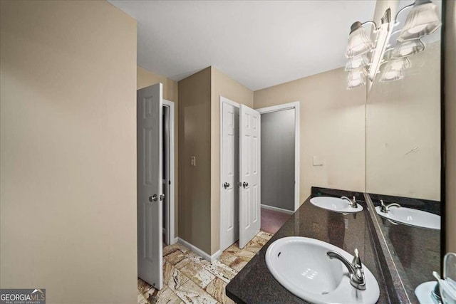 full bathroom with double vanity and baseboards