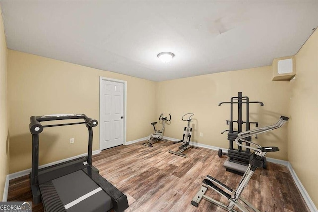 exercise area featuring wood finished floors and baseboards