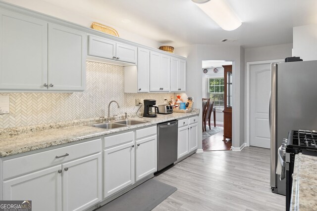 59 Kaiser Ct, Dallas, GA 30132 - kitchen featuring appliances with stainless steel finishes, a sink, tasteful backsplash, and white cabinets
