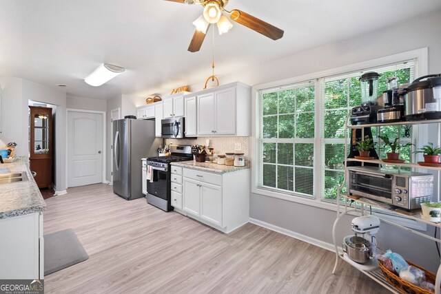 59 Kaiser Ct, Dallas, GA 30132 - kitchen featuring appliances with stainless steel finishes, light wood-style flooring, white cabinets, tasteful backsplash, and ceiling fan