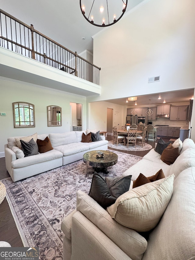 4736 Landing Water Path, Buford, GA 30519 - living room with a chandelier, a towering ceiling, wood finished floors, ornamental molding, and baseboards