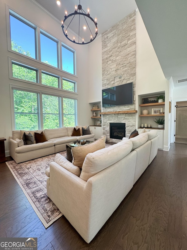 4736 Landing Water Path, Buford, GA 30519 - living area with a towering ceiling, a chandelier, a stone fireplace, crown molding, and baseboards