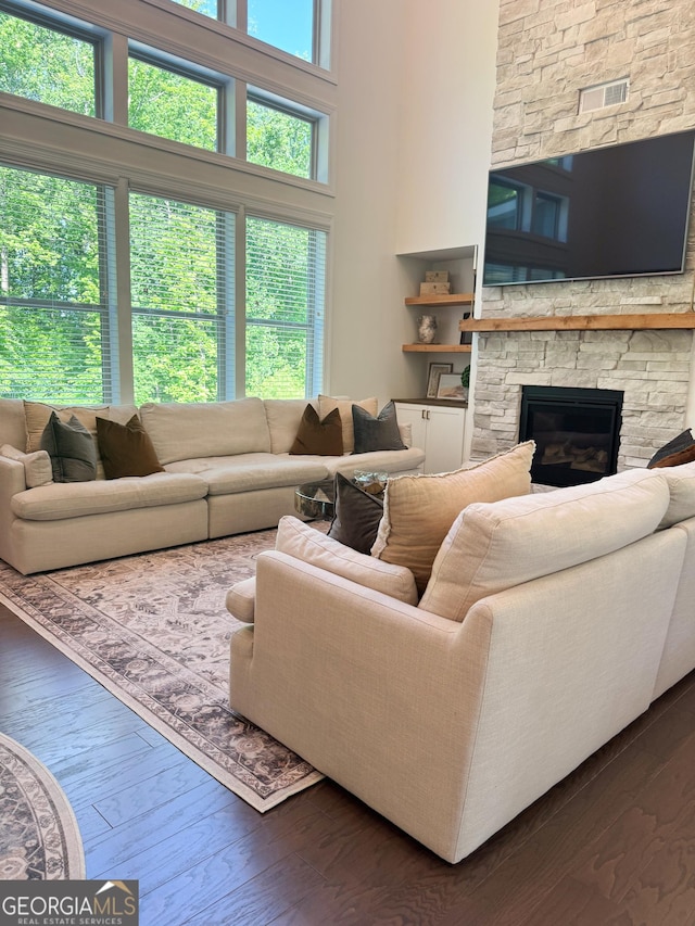 4736 Landing Water Path, Buford, GA 30519 - living room featuring dark wood-style floors, a stone fireplace, and a towering ceiling