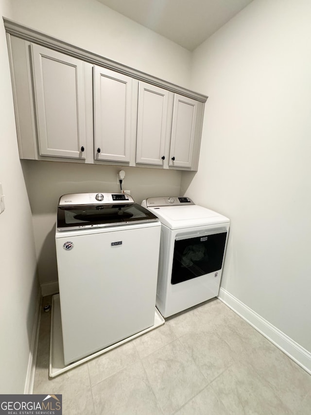 4736 Landing Water Path, Buford, GA 30519 - clothes washing area with washer and clothes dryer, cabinet space, baseboards, and light tile patterned floors