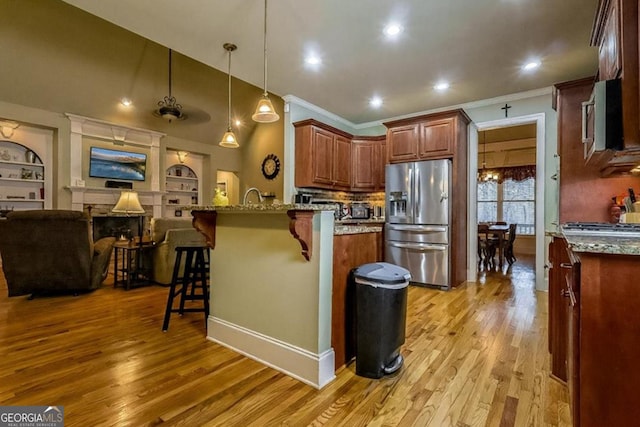 87 Marcus Ct, Ball Ground, GA 30107 - kitchen with appliances with stainless steel finishes, a breakfast bar, light wood-style flooring, a peninsula, and crown molding
