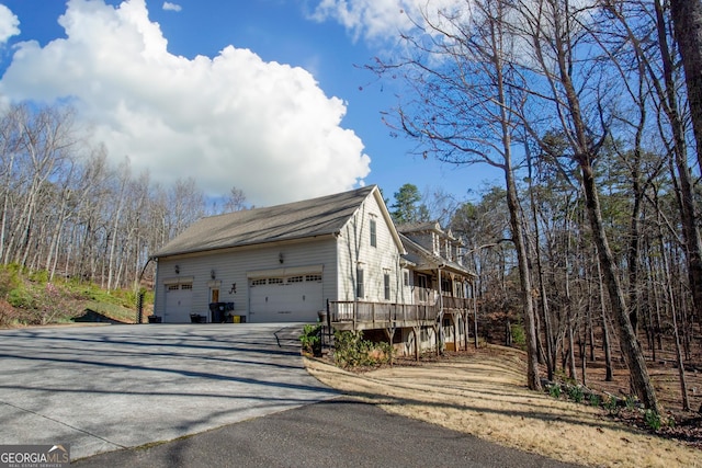 87 Marcus Ct, Ball Ground, GA 30107 - view of property exterior with driveway, a deck, and roof with shingles
