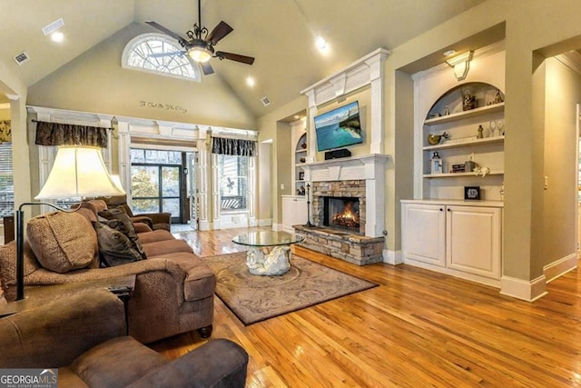 87 Marcus Ct, Ball Ground, GA 30107 - living room featuring a ceiling fan, wood finished floors, a fireplace, built in shelves, and high vaulted ceiling